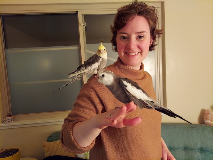Kate Mielke with two cockatiels